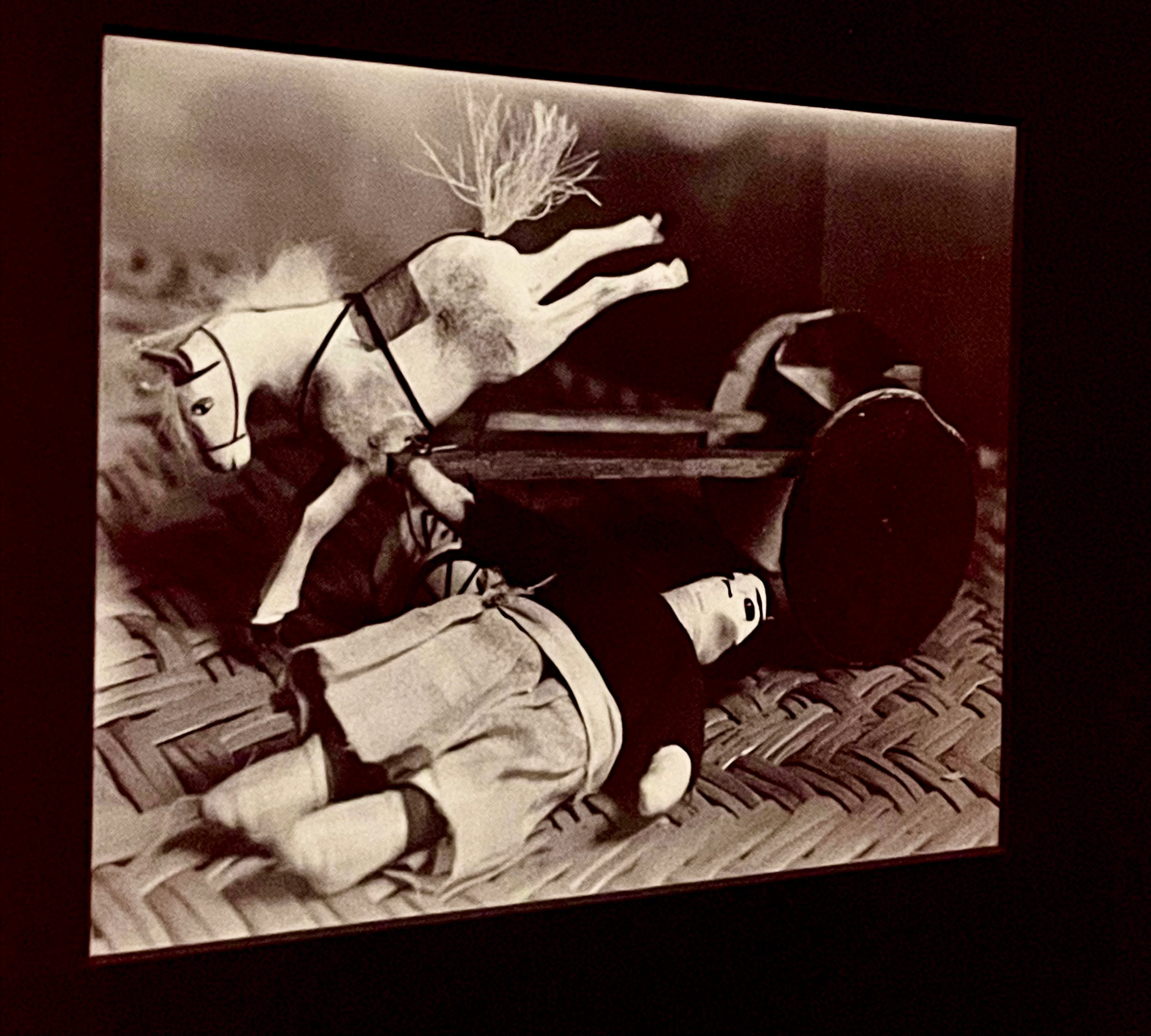 Black-and-white photograph of a toy-horse-and-cart tableau reconstructing the bus accident