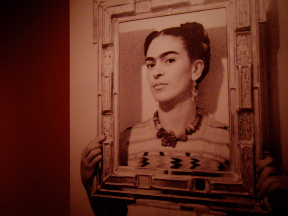 Frida Kahlo holding an empty frame around her face