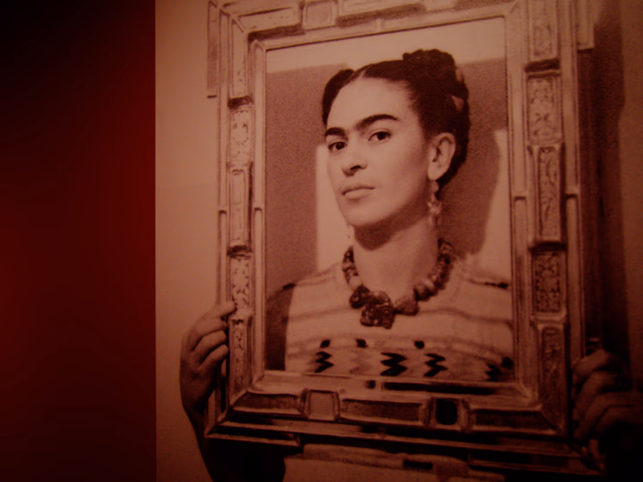 Frida Kahlo holding an empty frame around her face