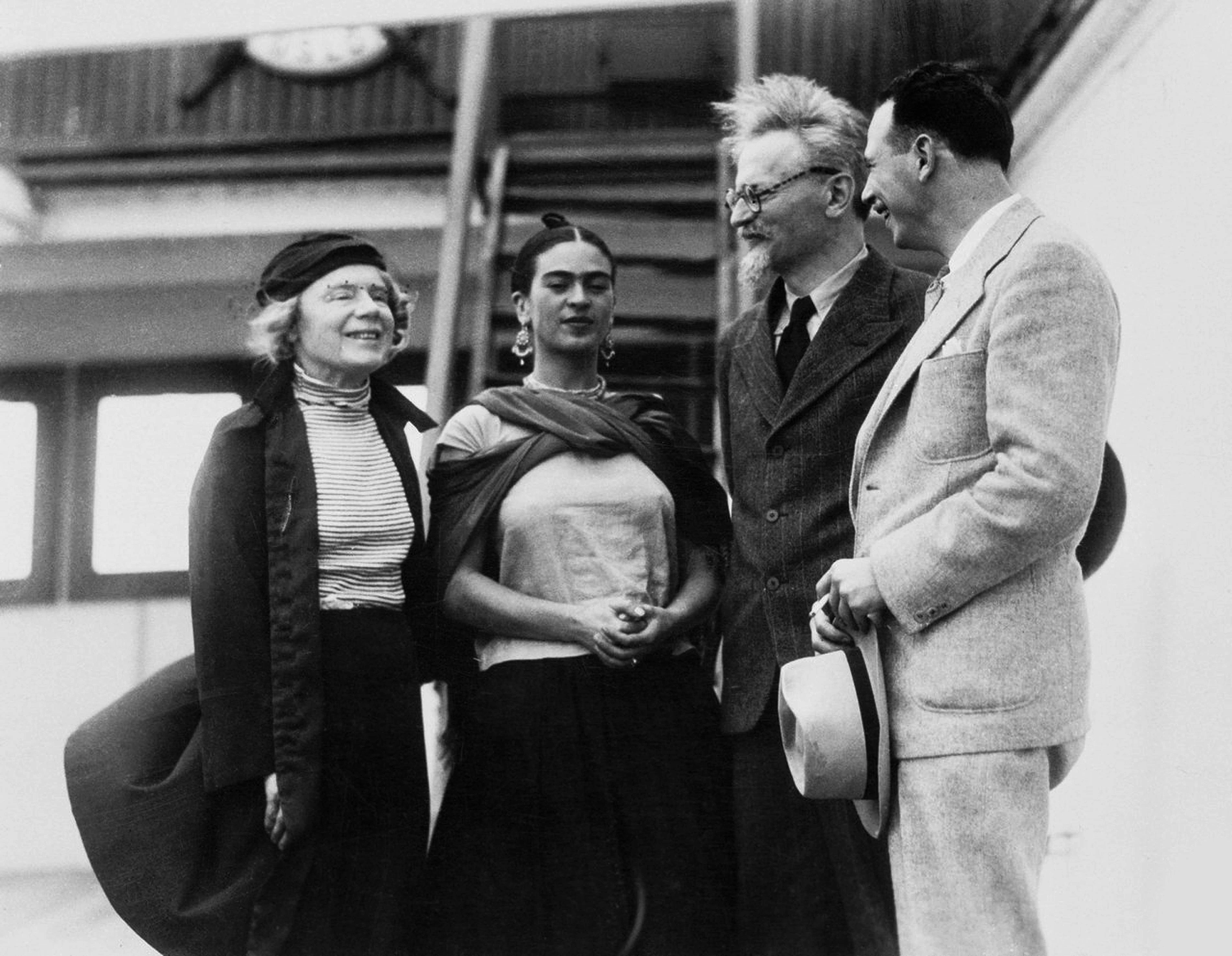 Black-and-white photograph of Frida Kahlo greeting Leon Trotsky and others on a ship’s deck